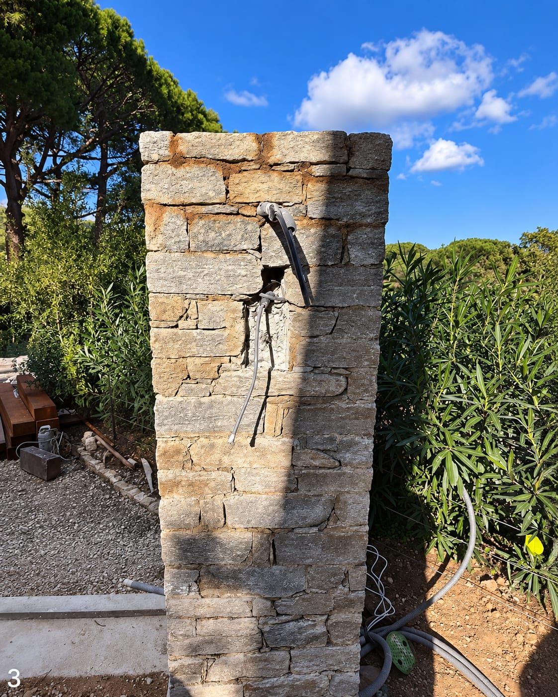 Poteau de portail en pierre naturelle terminé, sous le ciel bleu