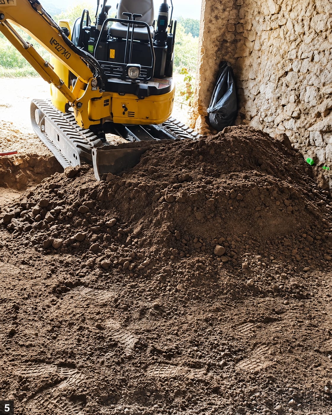 Godet de pelle chargé de terre et de gravats sur un chantier de démolition