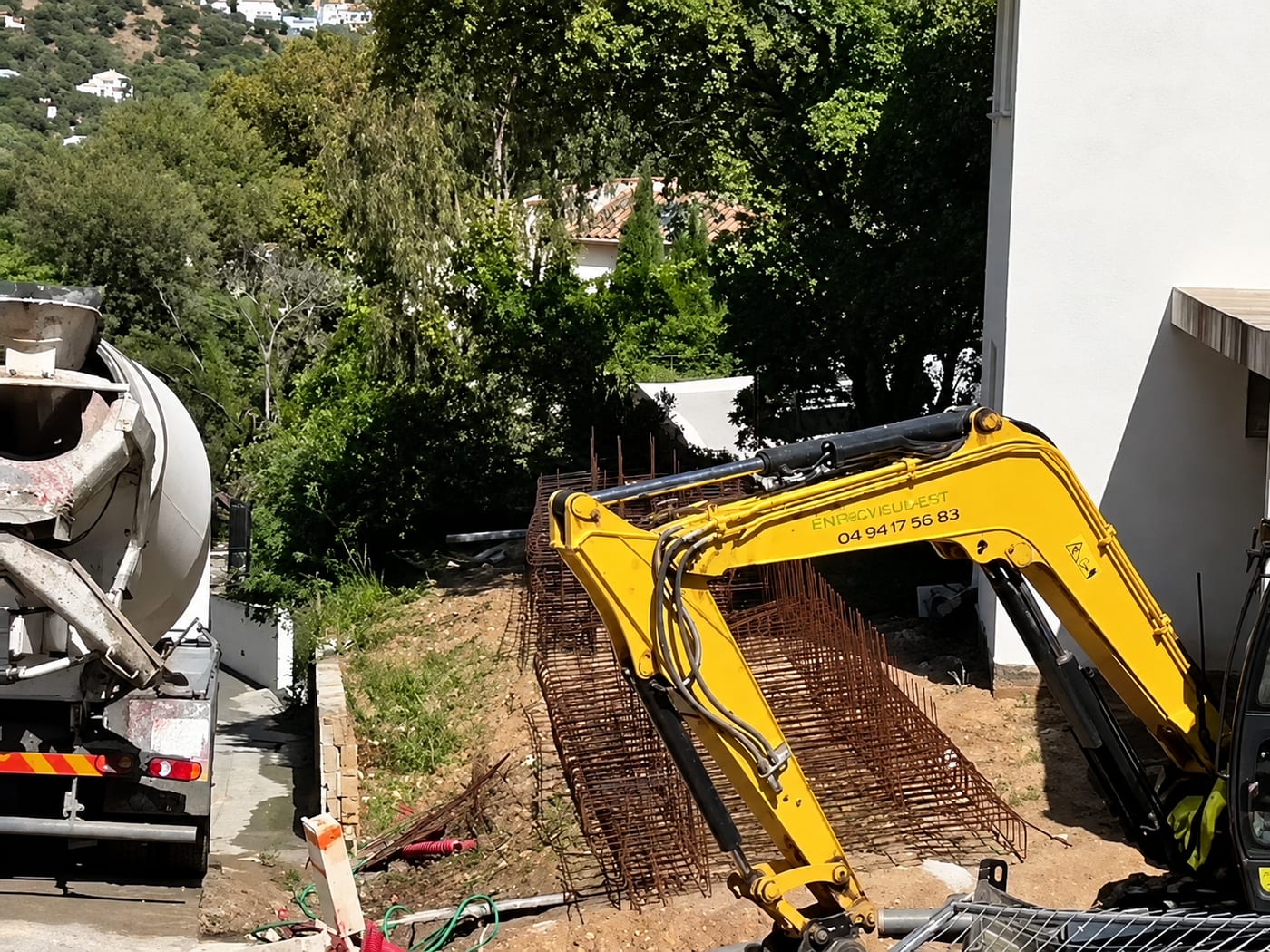 Toupie de béton, ferraillage et pelle mécanique sur un chantier en pente du golfe de Saint-Tropez